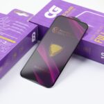 Szkło hartowane Apple iPhone 16 Pro / 17 Full Glue 9H na tle opakowania ochronnego
