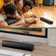 Głośnik Creative Stage Air V2 na podłodze obok rodziny oraz pod monitorem na biurku