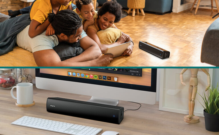 Głośnik Creative Stage Air V2 na podłodze obok rodziny oraz pod monitorem na biurku