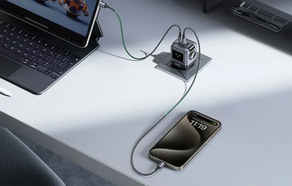 Ładowarka UGREEN Nexode RG wpięta w gniazdko przy biurku, ładuje tablet z klawiaturą i smartfon