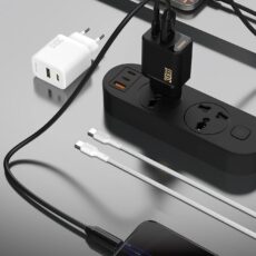Ładowarki Dudao A27TC w wersji białej i czarnej przy listwie zasilającej, jedna ładuje telefon – wizualizacja wygenerowana przez AI
